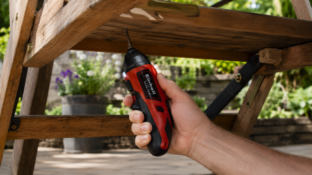 Einhell TE-SD 3,6 Li Mini-Akkuschrauber zieht Schraube unter einem Gartenstuhl fest