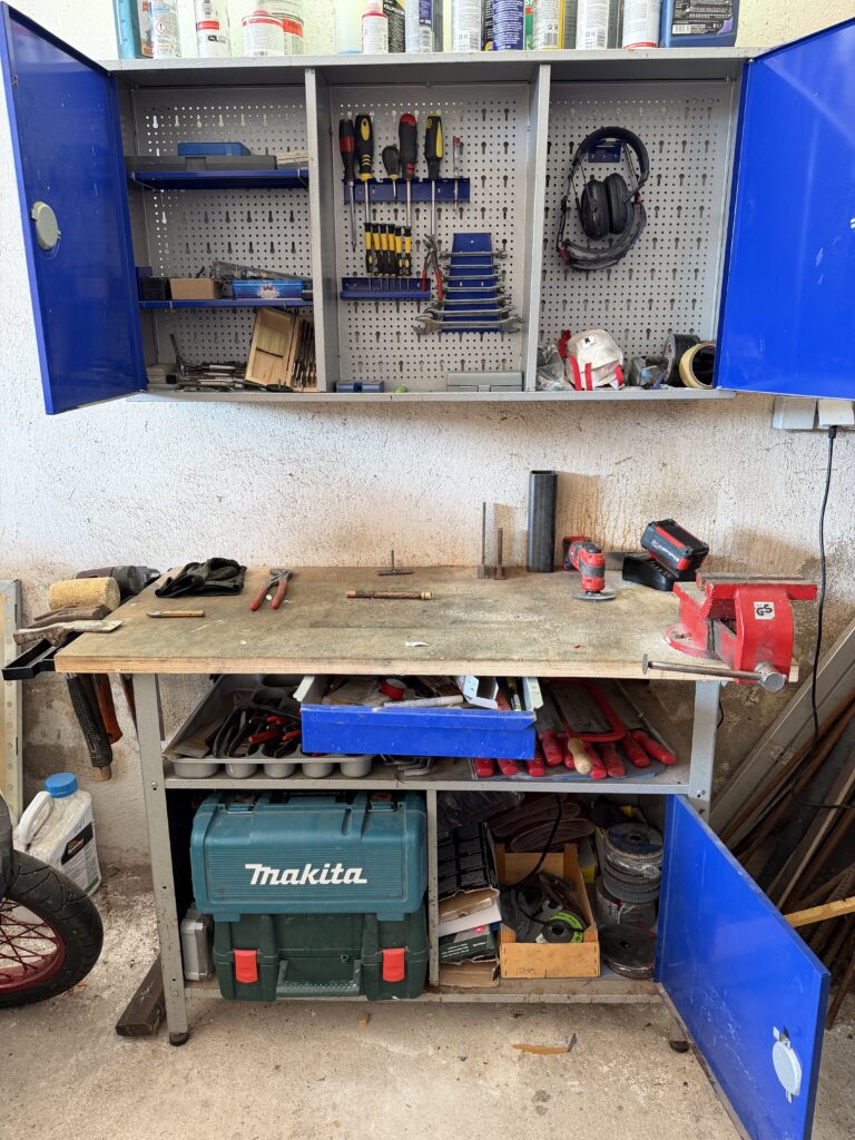Echte Werkstatt Einrichten in  der Ecke einer Garage mit Werkbank, offene Hängeschränken