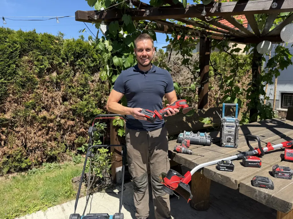 Akku-Gartengeräte und Wechselakkus unter einer Pergola für ein gemeinsames Akku-System in Garten und Werkstatt