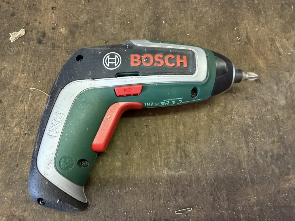 Bosch IXO 7 Akkuschrauber mit Gebrauchsspuren auf der Werkbank nach dreiviertel Jahr Praxistest