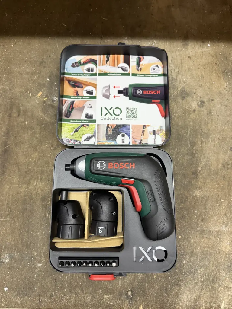 Bosch IXO 8 im geöffneten Koffer mit Winkelvorsatz, Exzentervorsatz und zehnteiligem Bitsatz