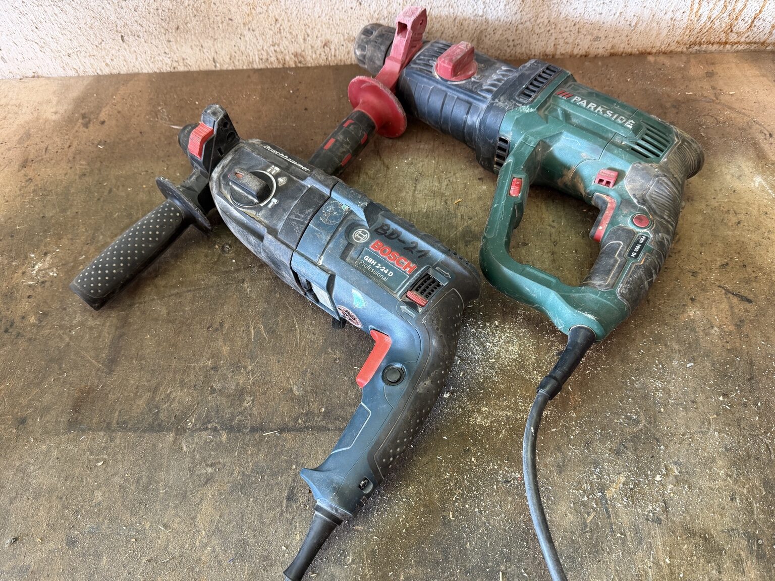 Gebrauchter Bosch Professional GBH 2-24 D und Parkside Bohrhammer nebeneinander auf einer Werkbank