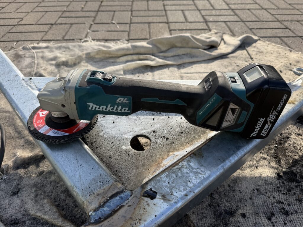 Akku-Winkelschleifer mit bürstenlosem Motor und 5,0-Ah-Akku auf einem verzinkten Stahlrahmen, Fächerscheibe montiert