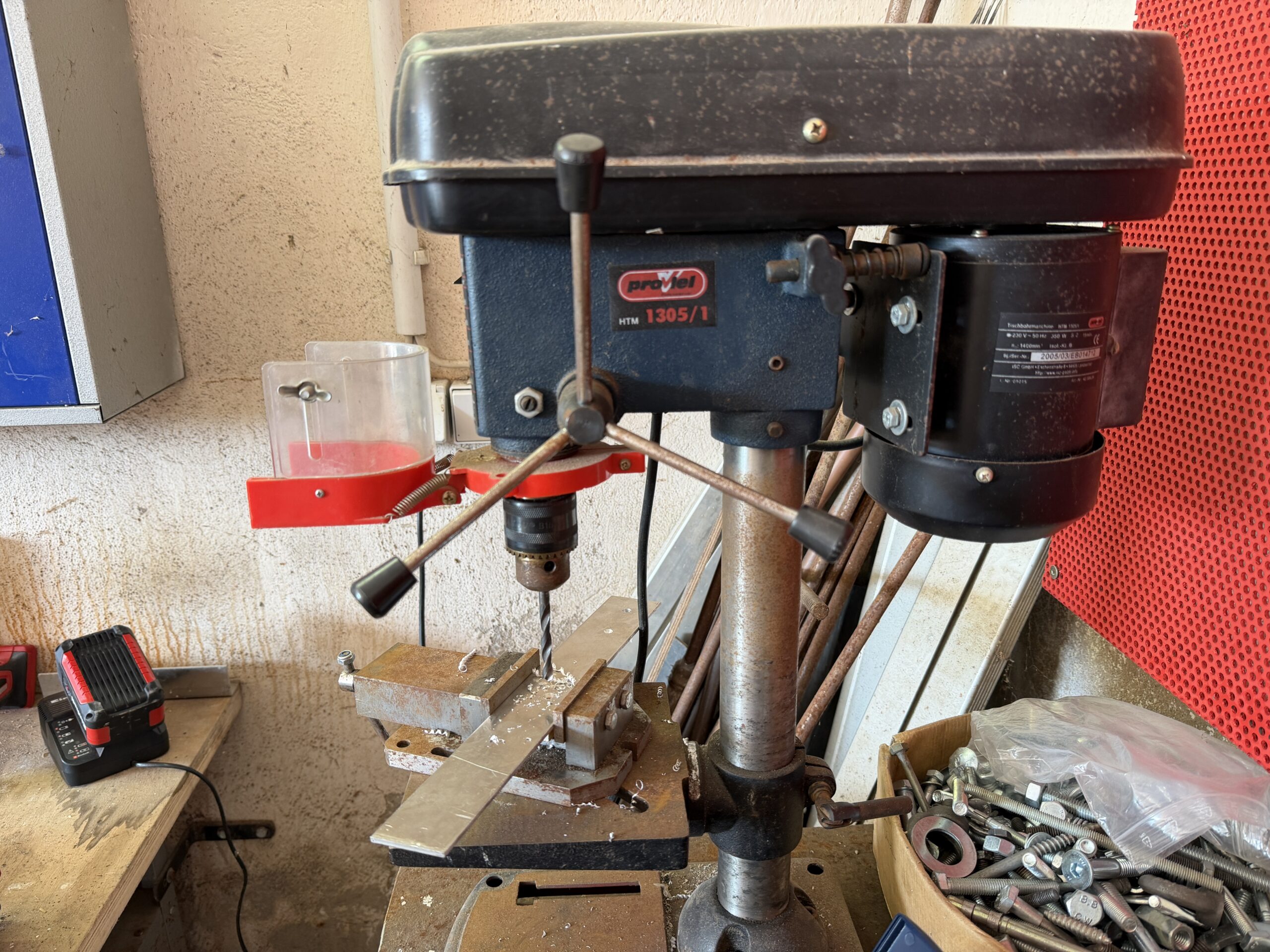 Ständerbohrmaschine mit eingespanntem Metallprofil und sichtbaren Bohrspänen auf dem Maschinentisch