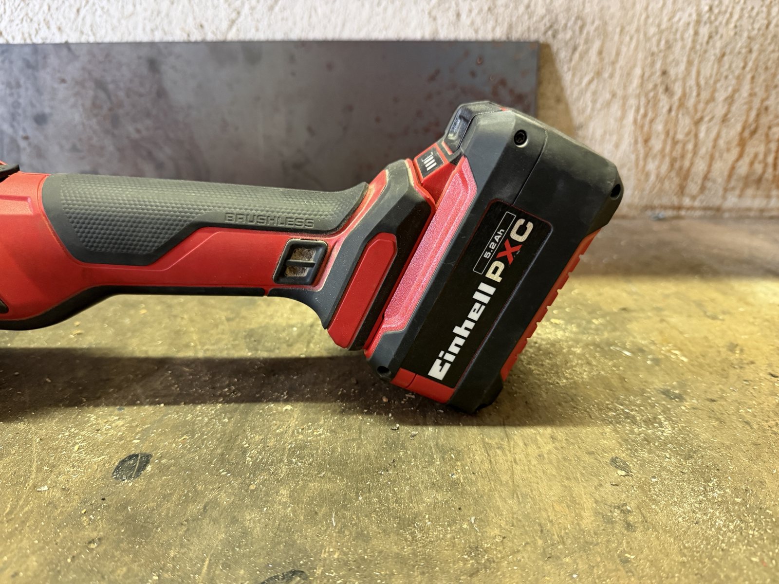 Detailansicht der Einhell AXXIO mit Brushless-Schriftzug am Gehäuse und eingestecktem Power-X-Change-Akku mit 5,2 Ah