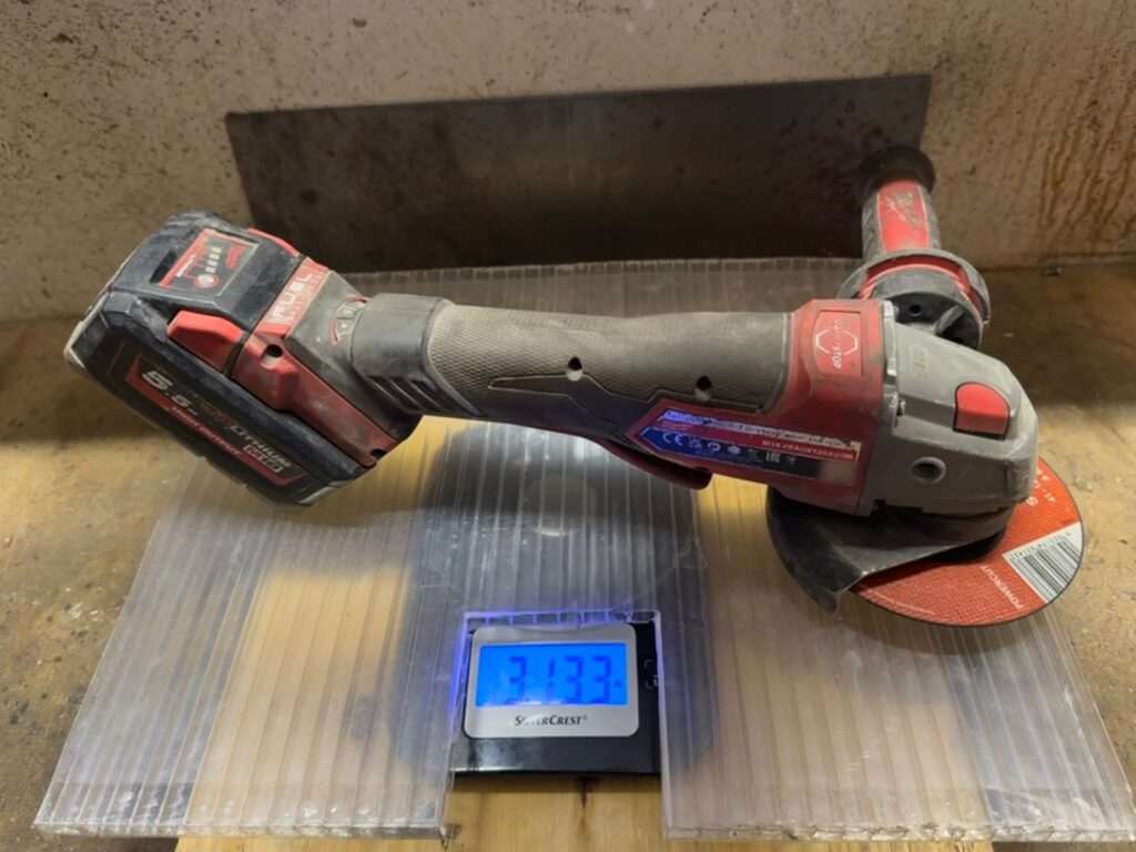 Digitale Küchenwaage zeigt 3,133 kg, darauf die Milwaukee M18 FSAGV125XPDB mit 5,5-Ah-Akku