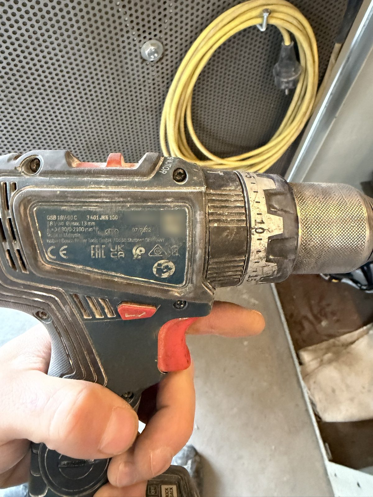 Bosch-Schlagbohrschrauber GSB 18V-90 C mit abgegriffenem Drehmomentring und Typenschild, in der Hand gehalten