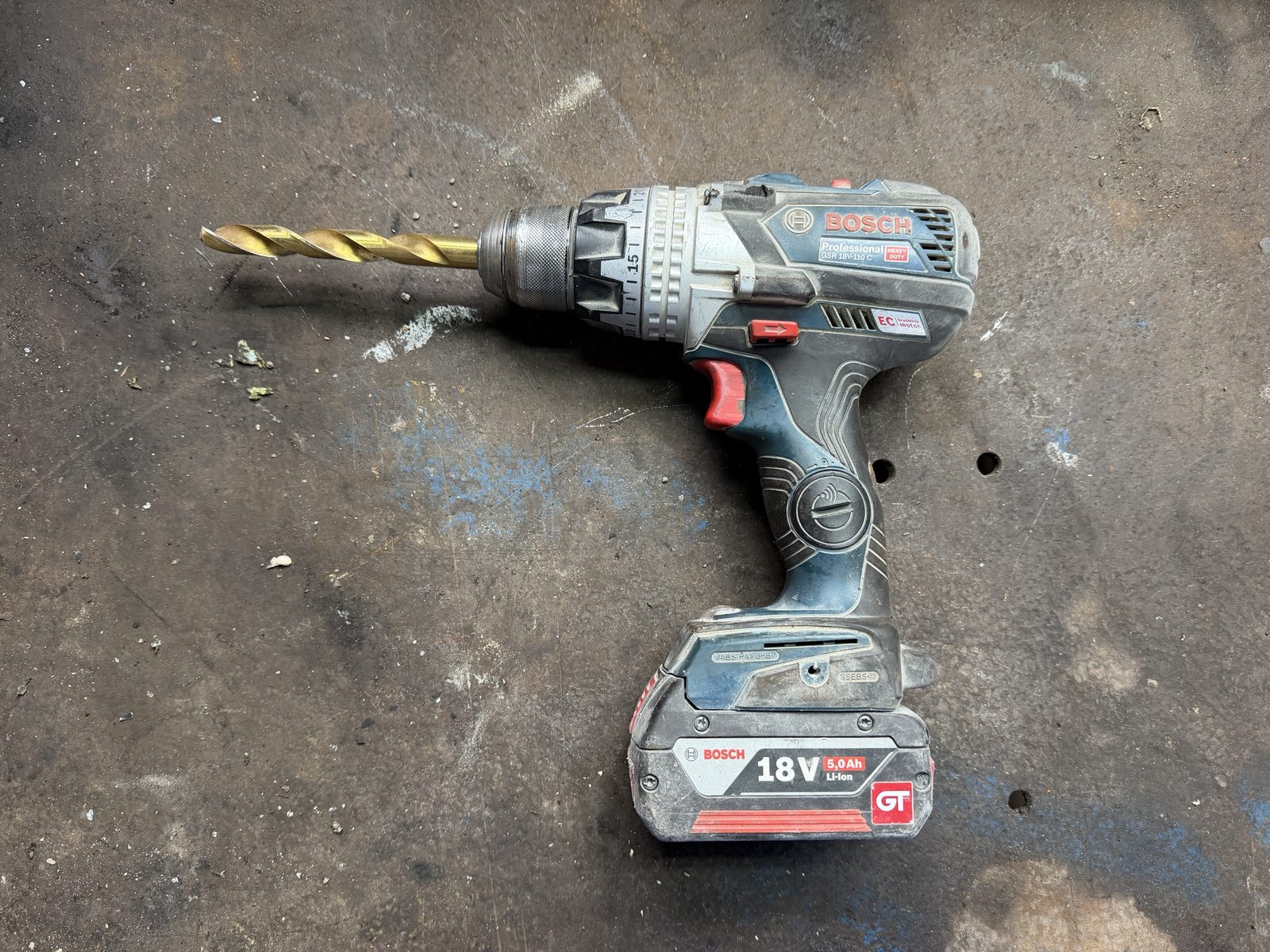 Bosch Professional GSR 18V-110 C Heavy Duty mit 18-V-Akku 5,0 Ah und Metallbohrer auf einer Werkbank
