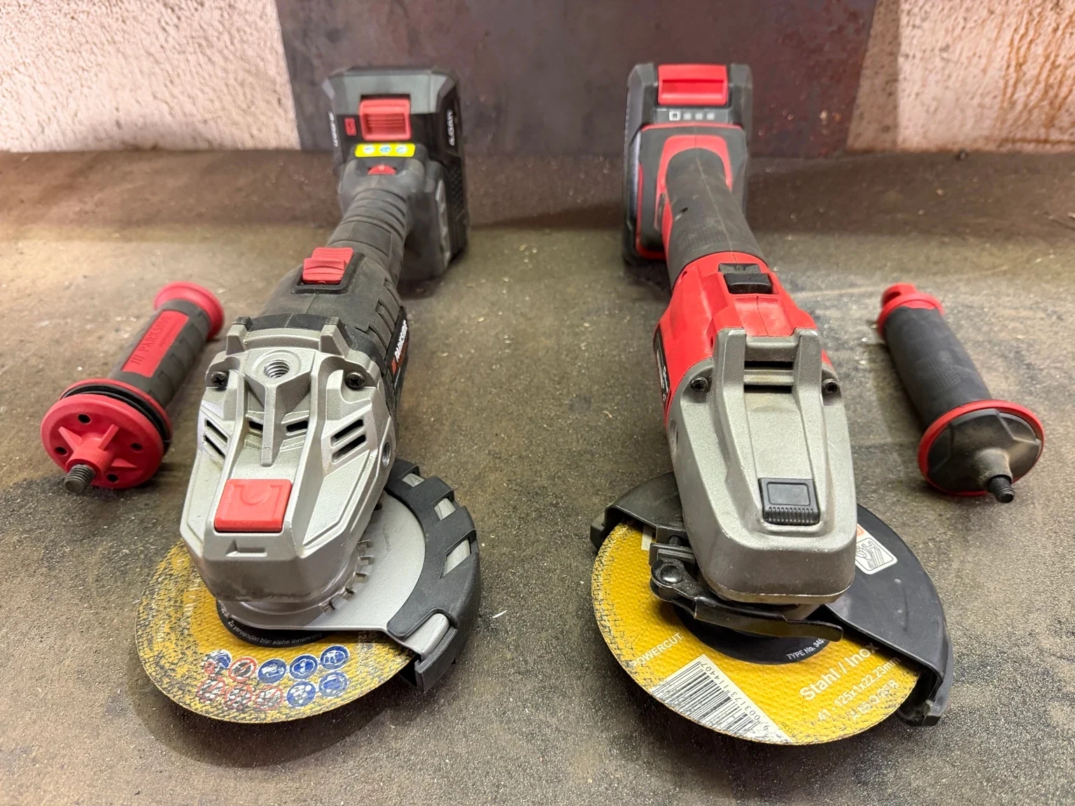 Getriebeköpfe von Parkside links und Einhell rechts mit rotem beziehungsweise schwarzem Arretierknopf und montierten Trennscheiben.